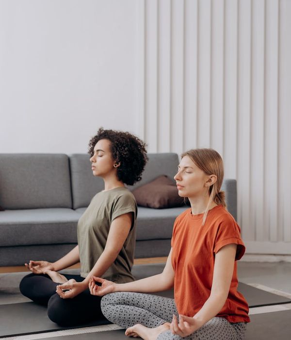 Woman in a calm yoga pose in a bright room.